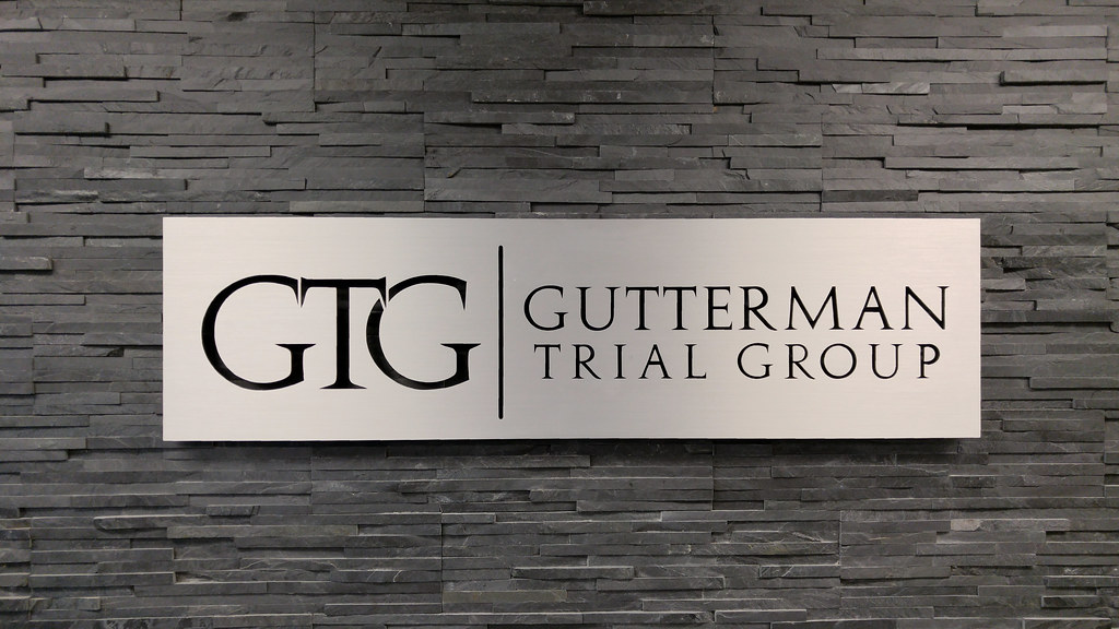 Aluminum Panel sign with reverse cut through logo and lettering for law office lobby installed on custom tile wall