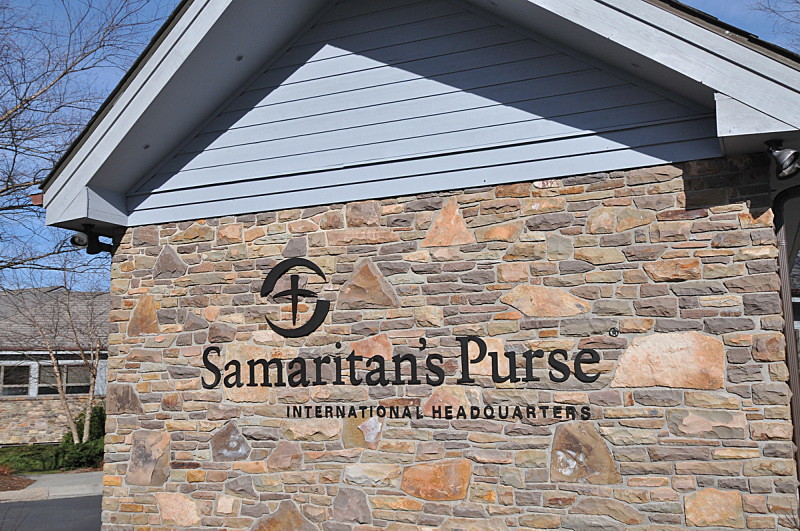 dark oxidized bronze letters and logo installed to rough stone wall