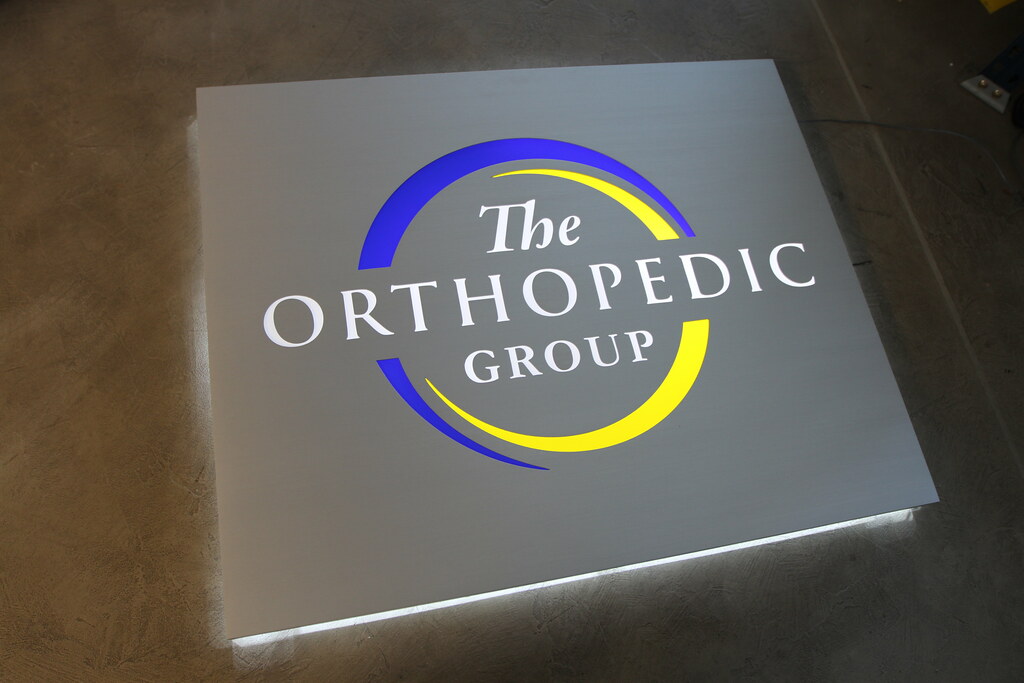 Fabricated panel sign with cut out accent lighted letters and halo backlight accent