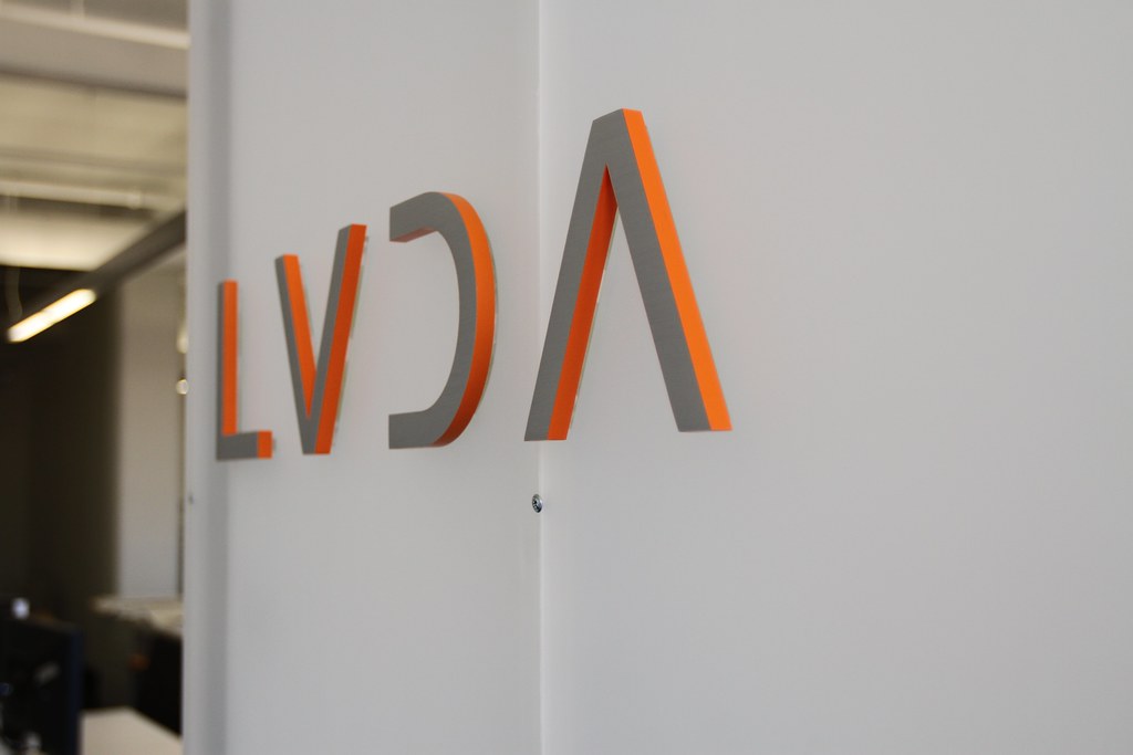 Orange acrylic letters with silver laminate faces DF tape install on customer dividing wall panels