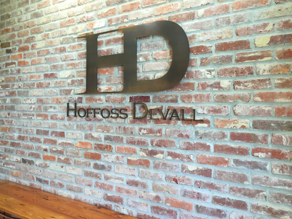 Oxidized bronze custom logo and lettering installed interior lobby on brick